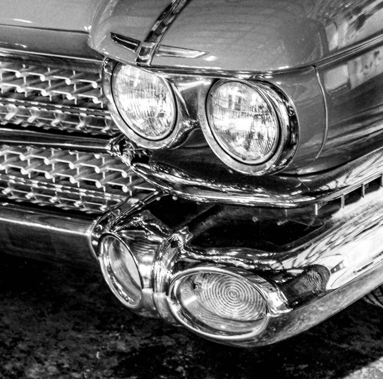 Closeup of a 1970 car’s headlights. 
