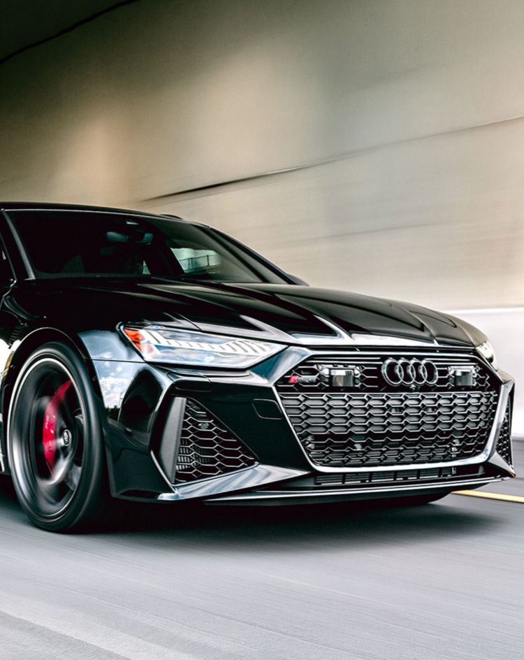 Black performance car driving at speed through a tunnel, highlighting its glossy finish and ideal conditions for showcasing automotive paint protection film. 