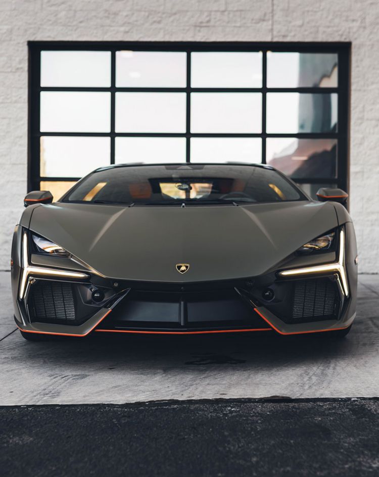 Matte‑finished sports car parked in front of a glass garage door, showcasing the smooth, non‑glossy look achievable with matte paint protection film. 