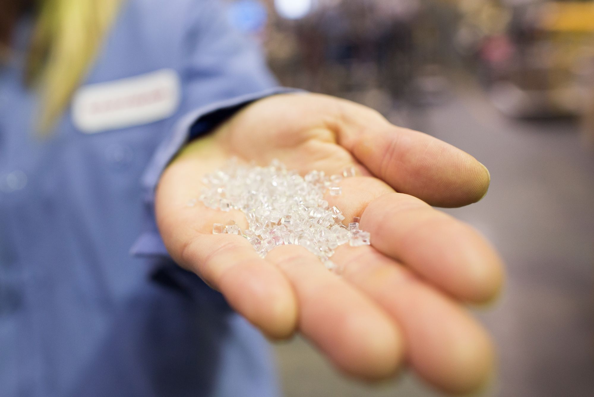 Close up of recycled plastic pellets on researcher’s hand. 