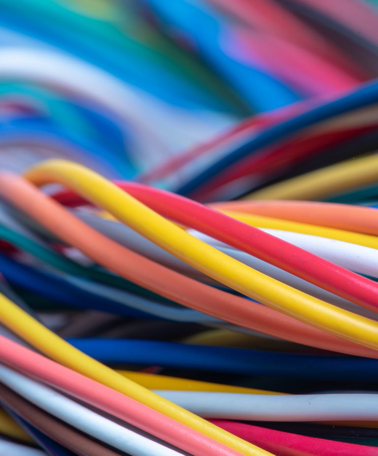 Multicolored electrical cables wind around each other. 