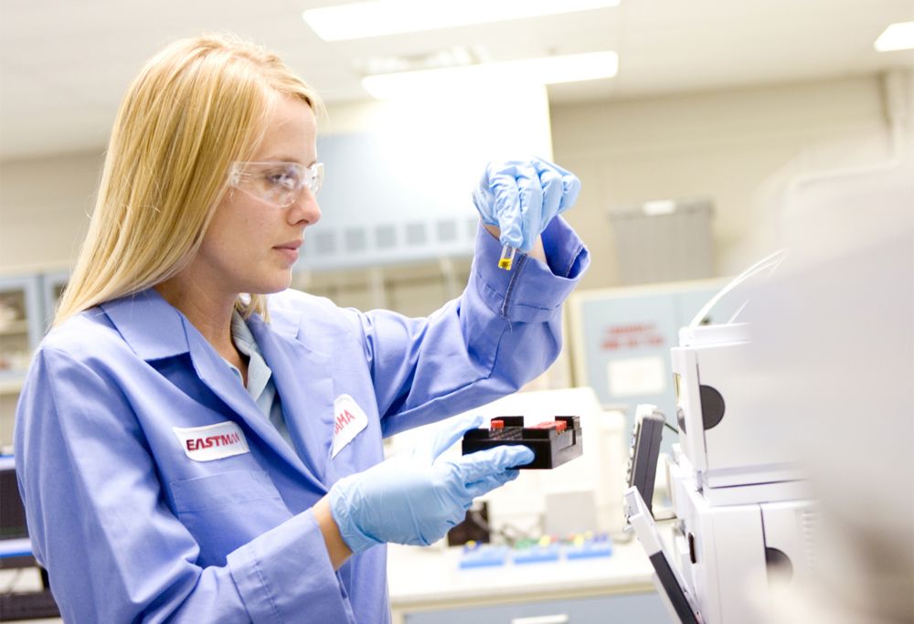 Woman examines a small vial. 