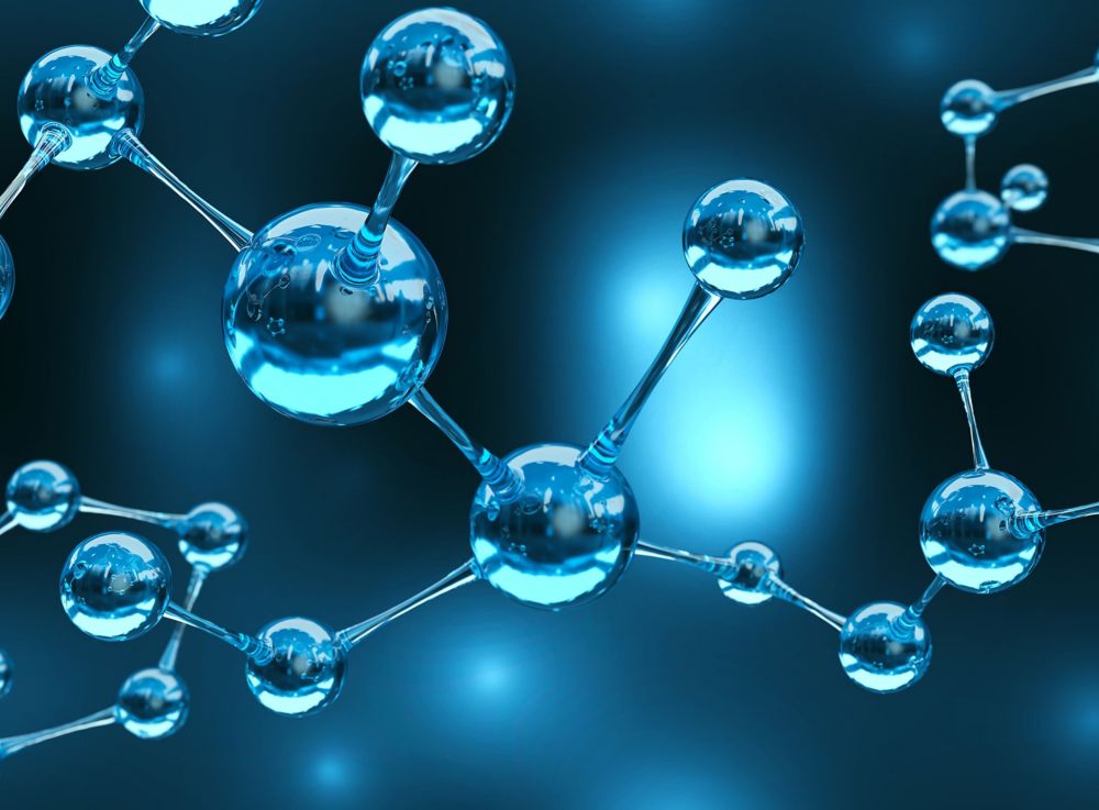 Two lab employees in blue coats working with glassware and laboratory equipment. 