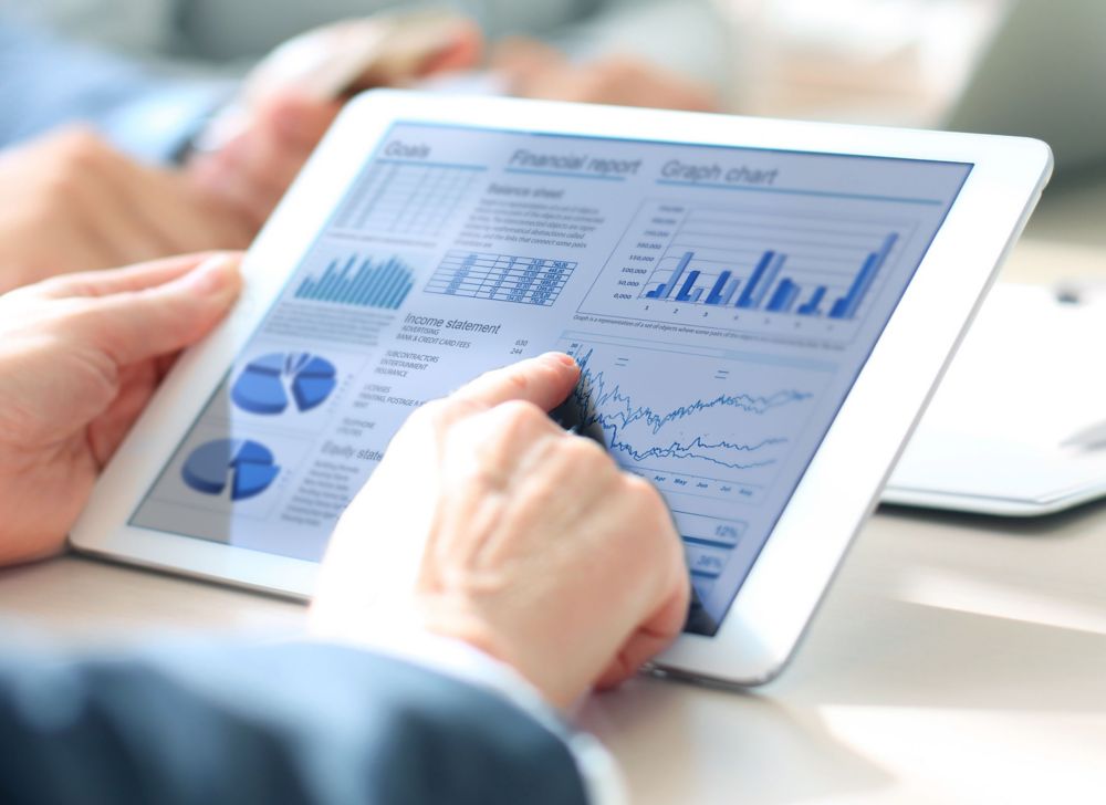 A person pointing at a graph on a tablet 