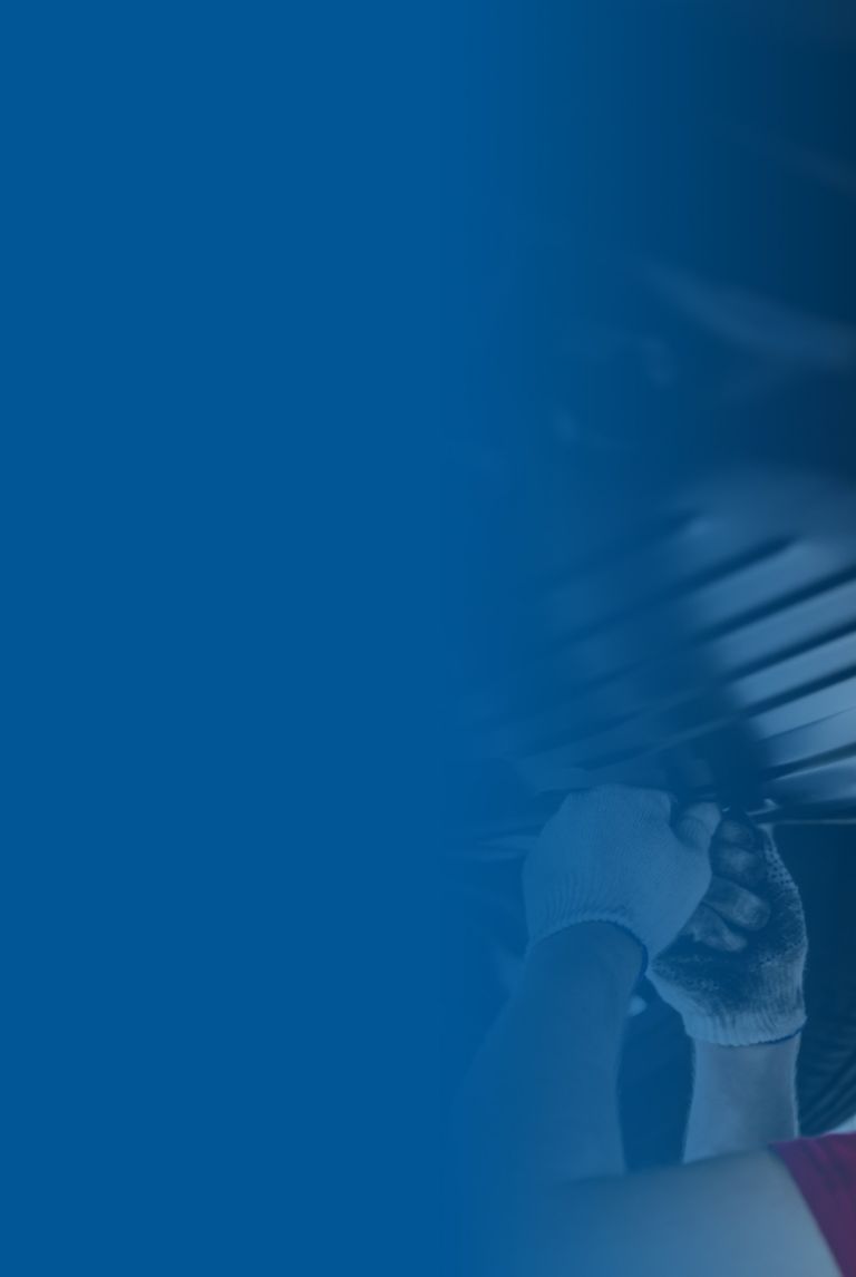 Mechanic installs underbody protection on a raised car. 