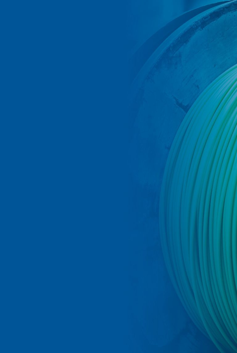 Blue banner fade over a picture of a green cable is wound around large spools. 