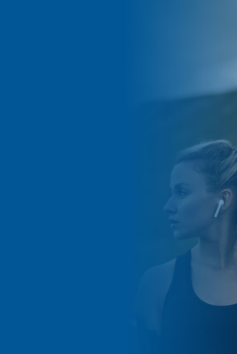 Blue banner fades over a photo of a woman exercising in the mountains while wearing wireless ear buds 