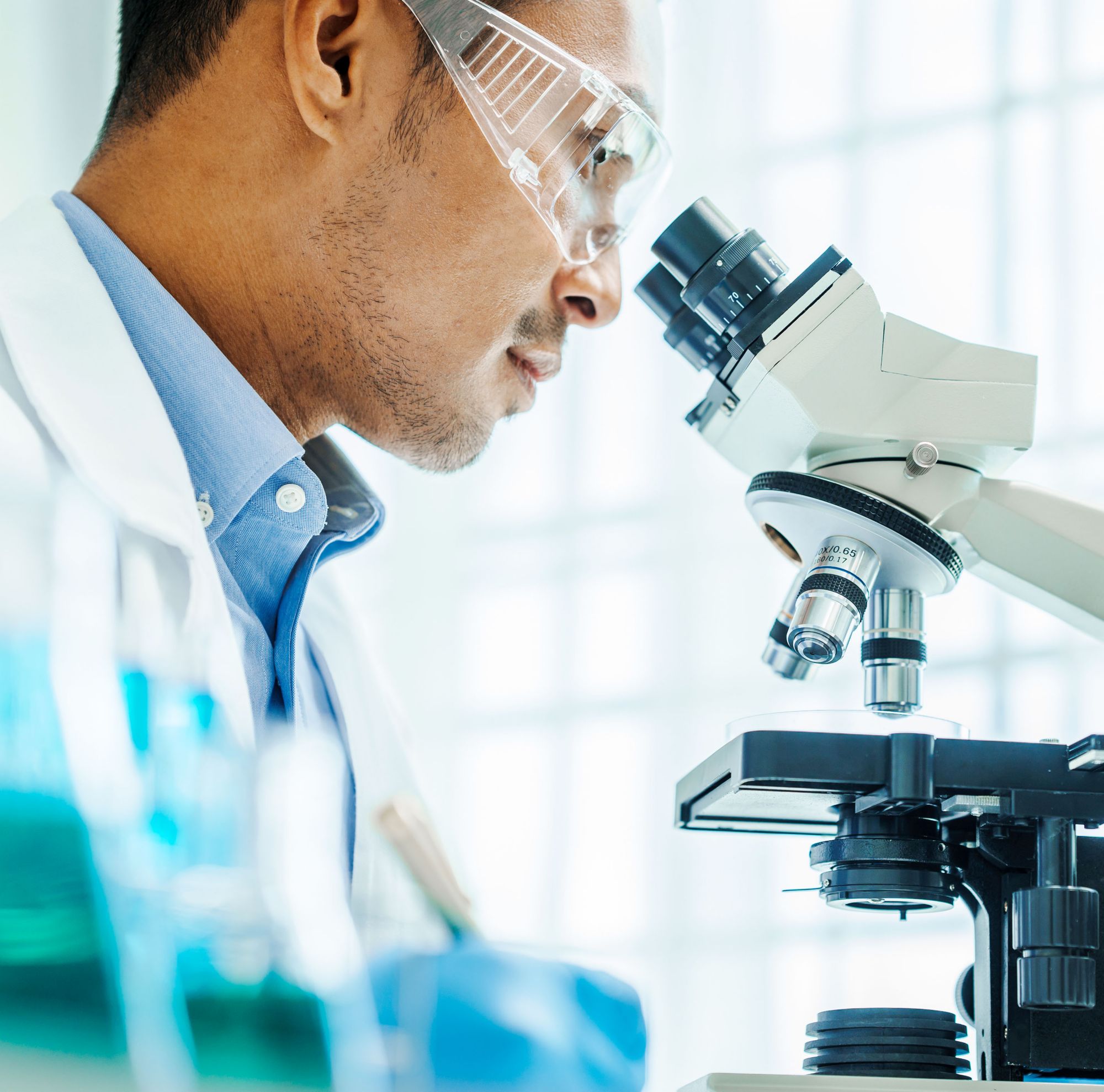 A scientist looking through a microscope. 
