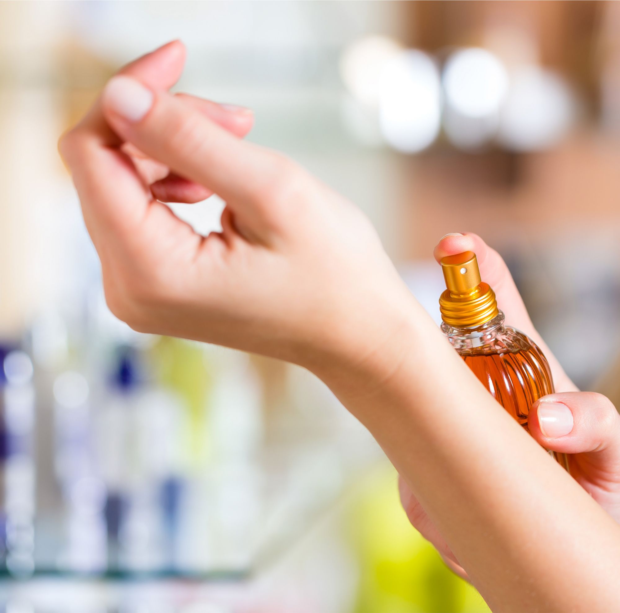 Perfume is sprayed on a wrist in a retail store.   