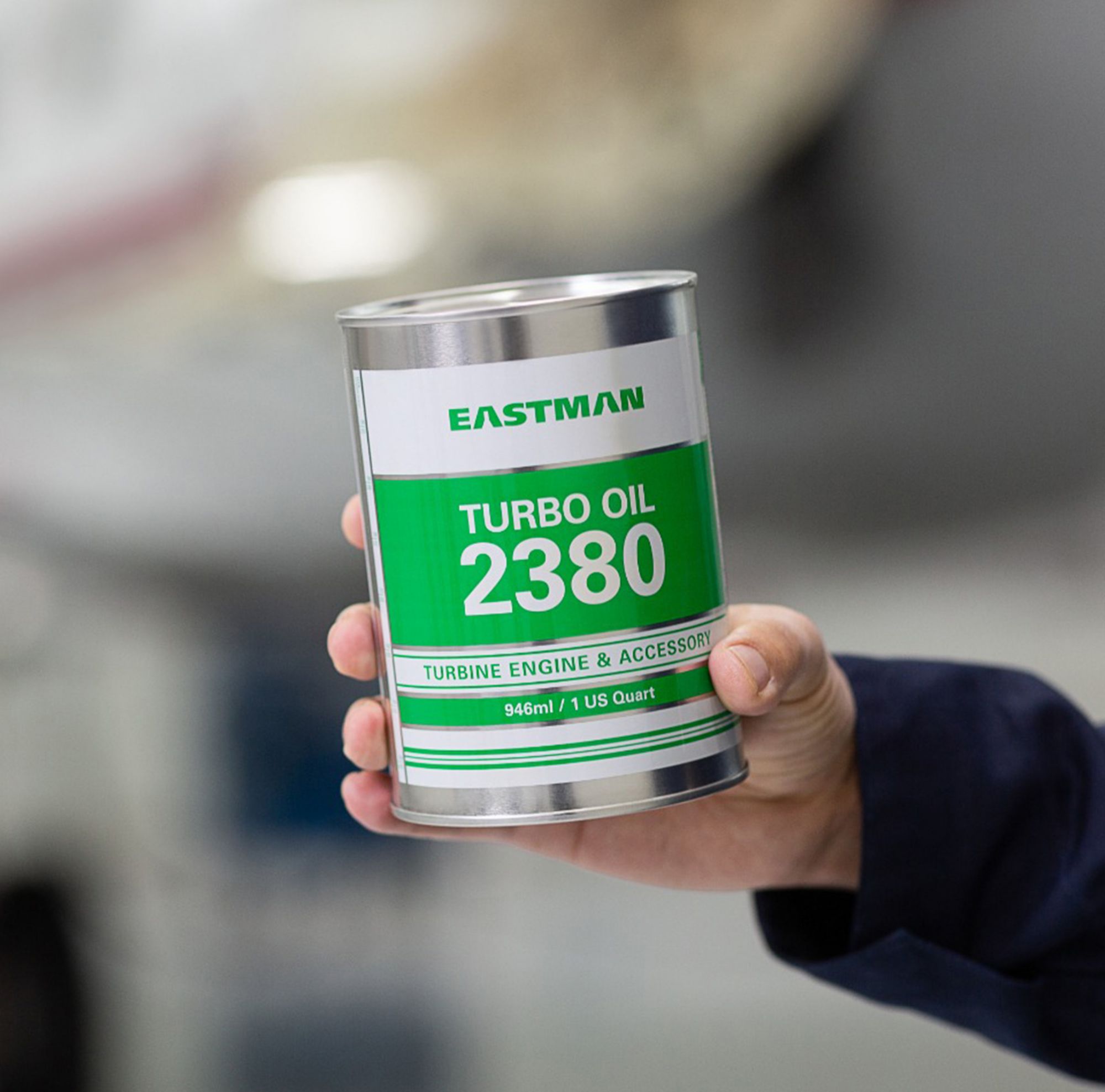 A close-up of someone holding a can of turbo oil. 