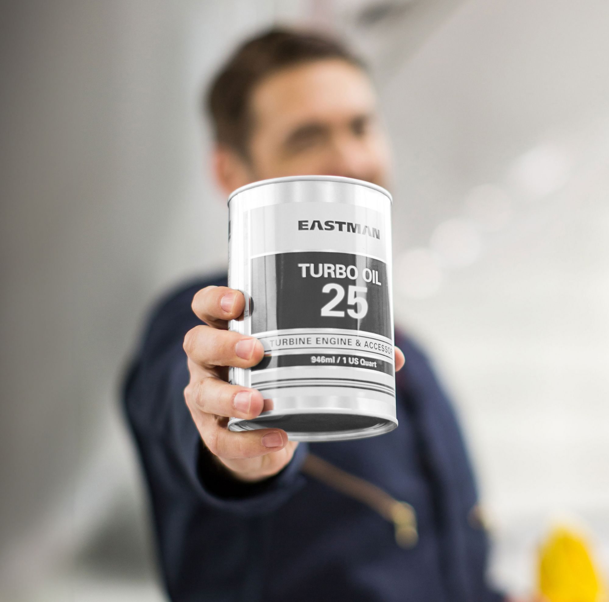 A man holds a turbo oil can in front of him. 