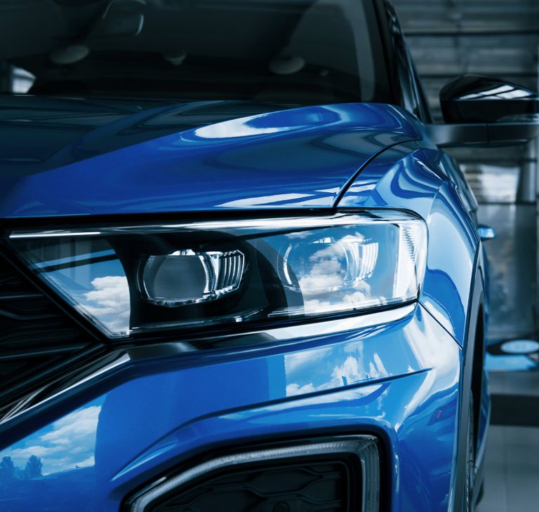 Close-up of a blue car’s headlights. 