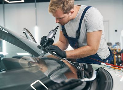 Auto glass repair technician fixing a car windshield.