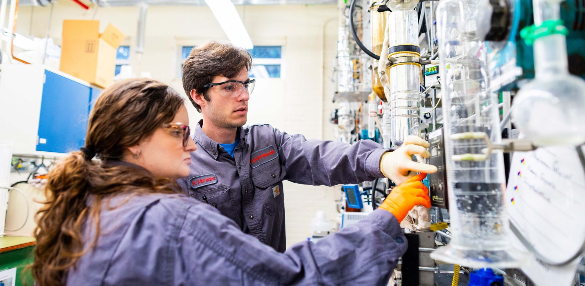 Two Eastman chemical engineers test a machine. 