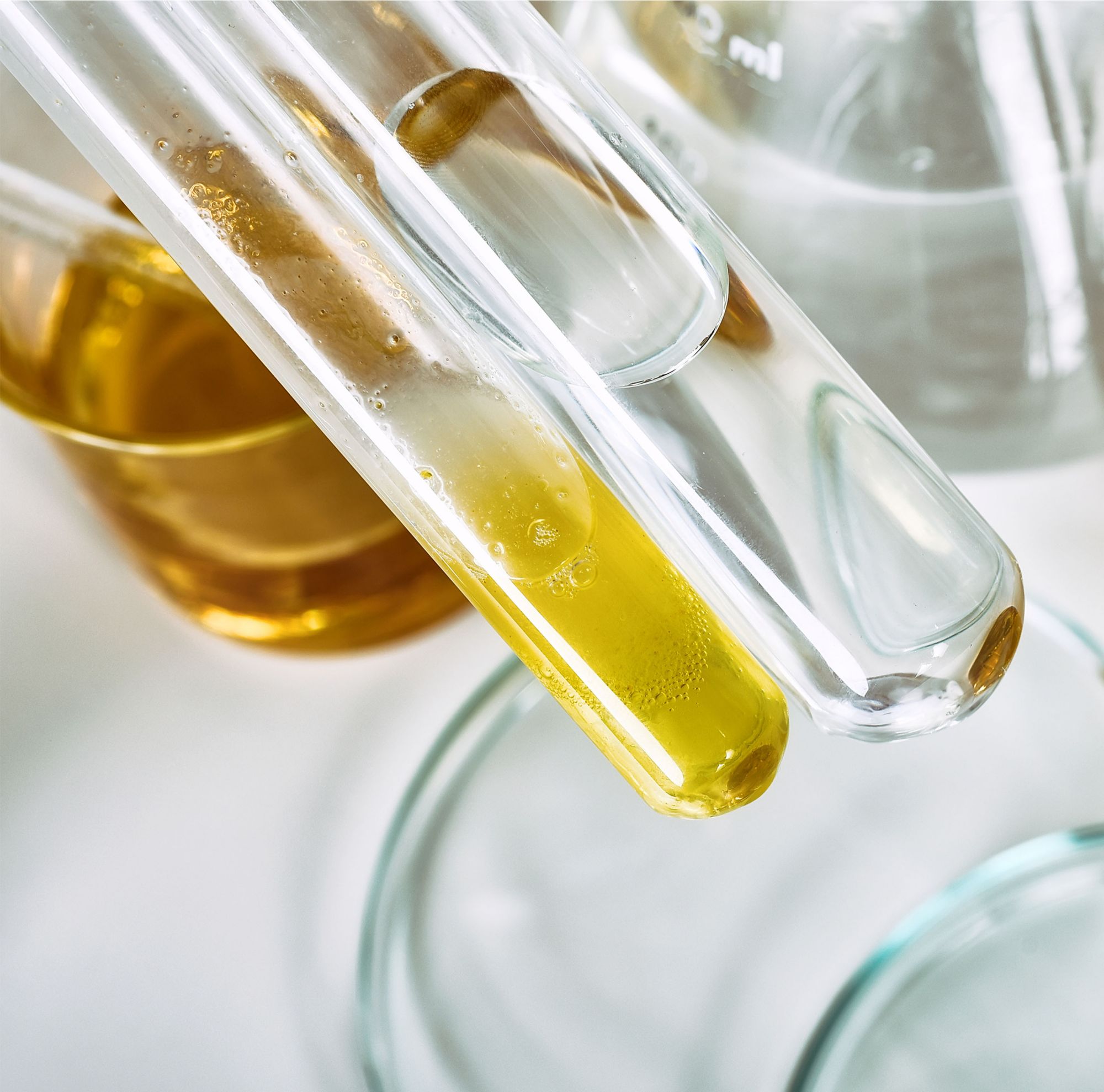 Two test tubes, one containing yellow liquid and the other clear liquid. 