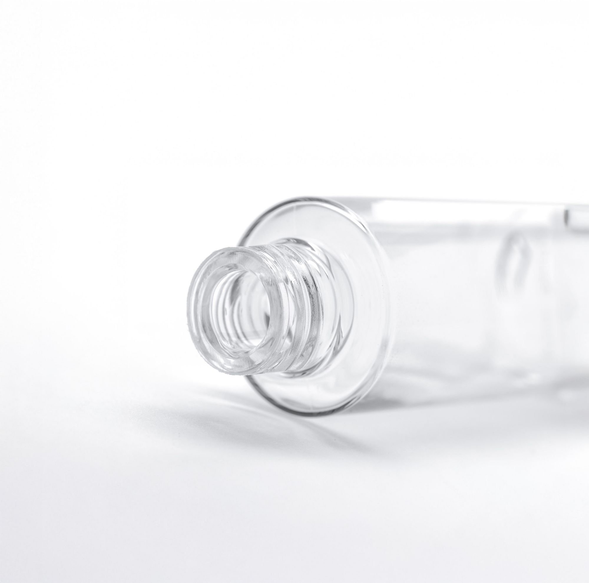A clear and empty cosmetic bottle made from Eastman Cristal One Renew IM812 resin.   