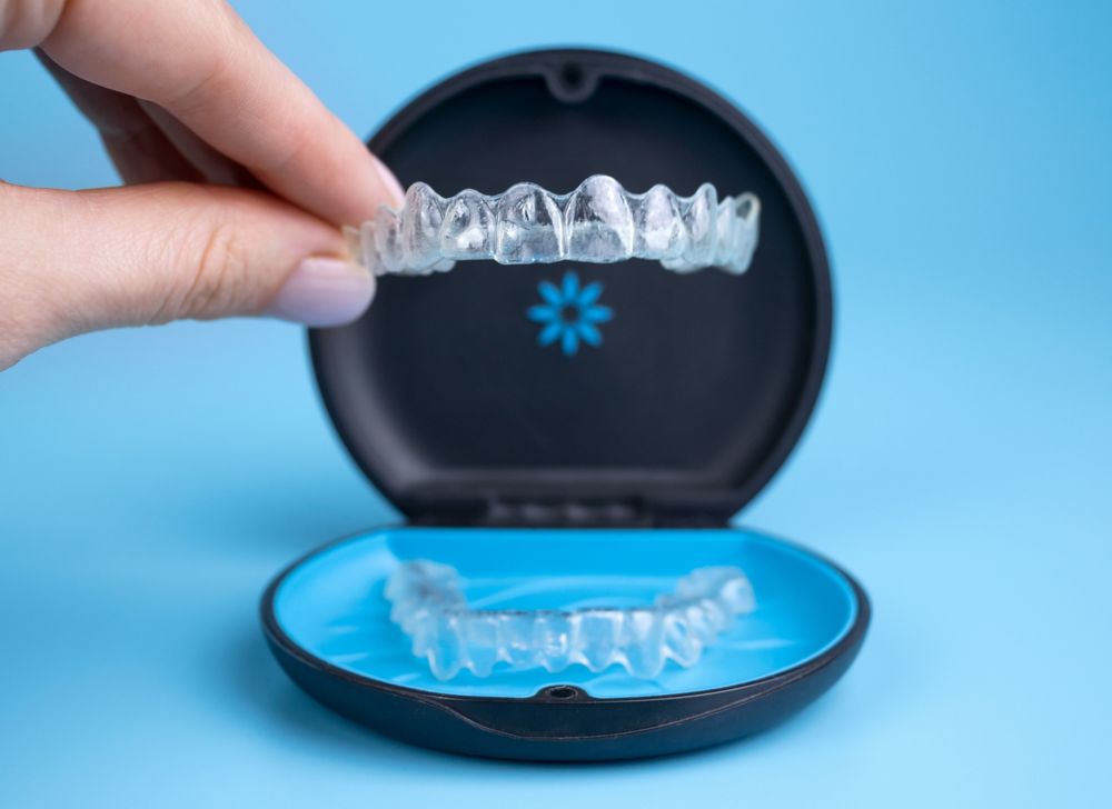 A hand holding clear dental aligners.   
