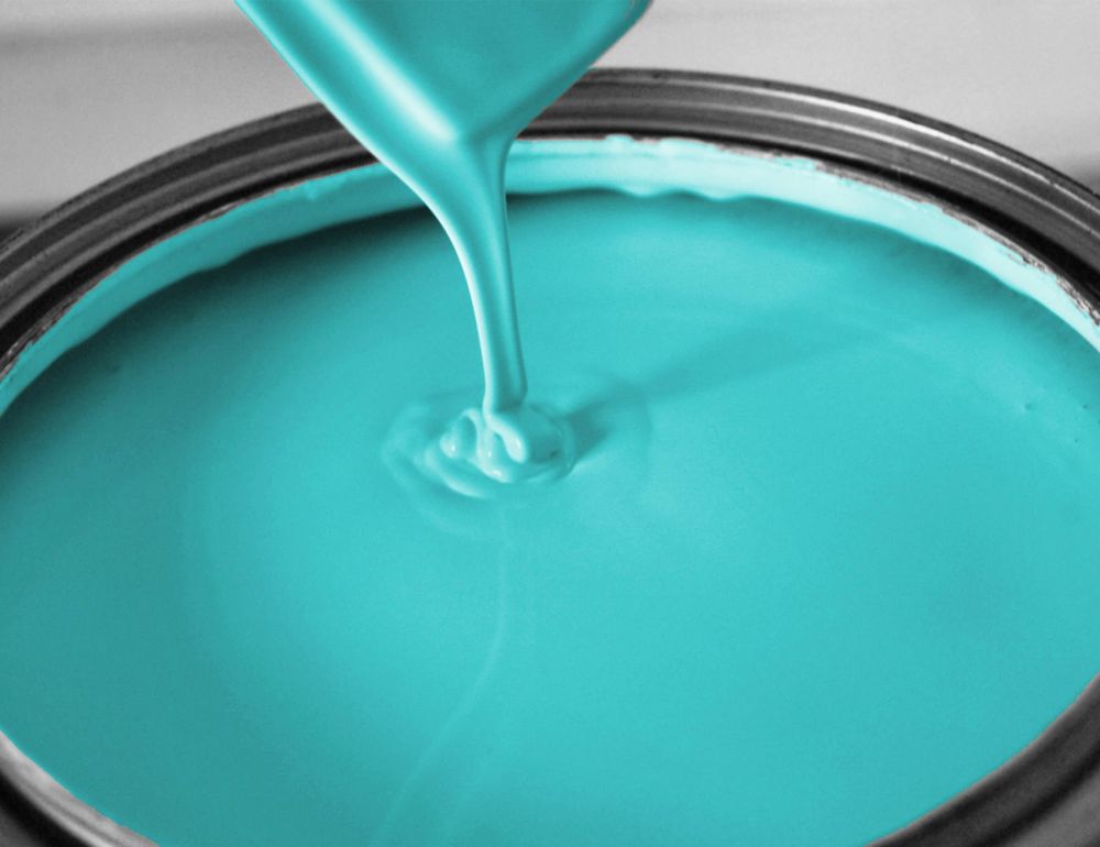 Light blue paint pours into a bucket. 