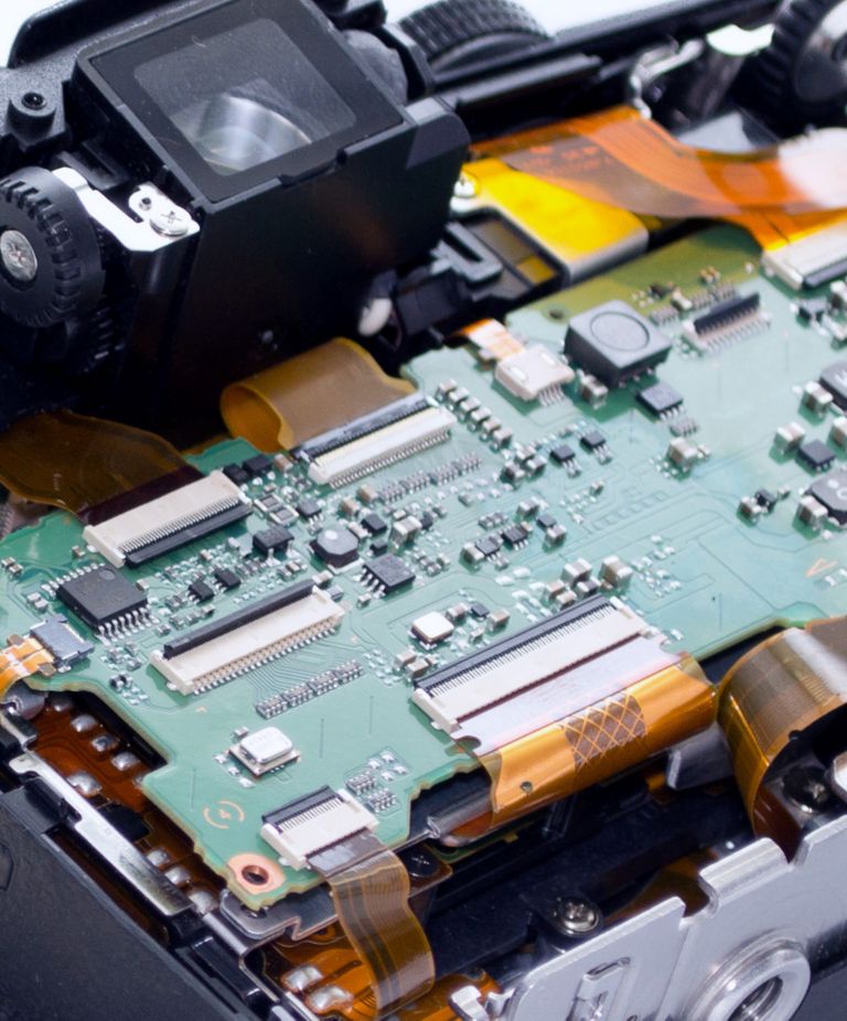 The circuit board inside a disassembled camera is shown 