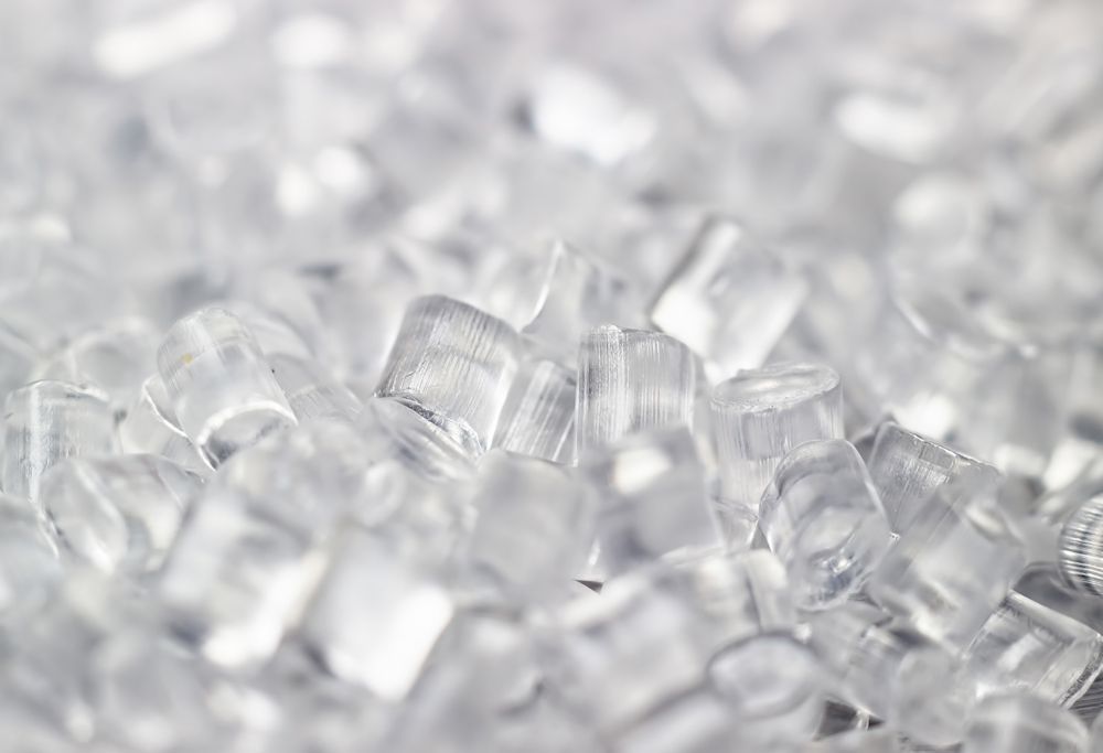 Clear resin pellets are shown close up. 