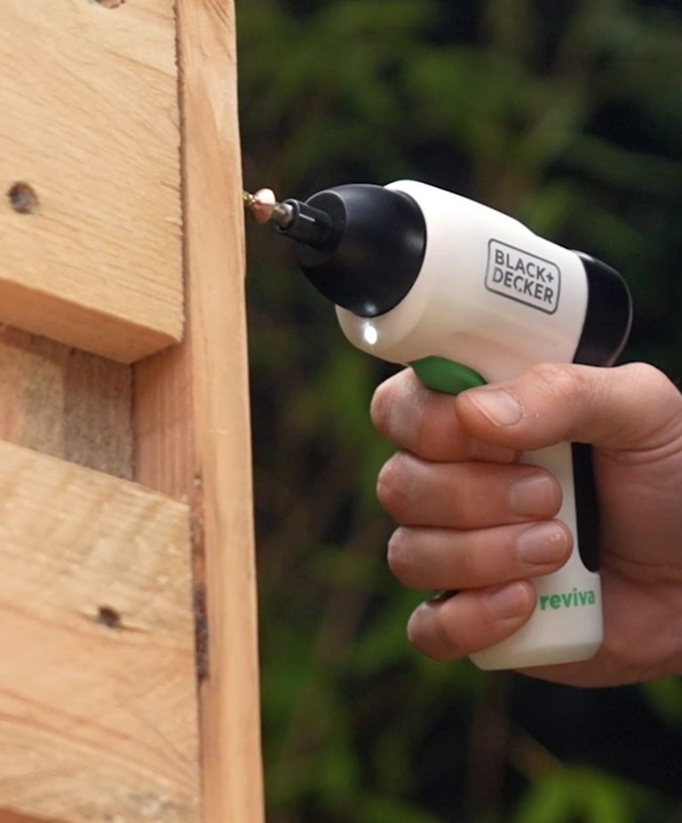 A close-up of a person using a Black and Decker power screwdriver made with Tritan. 
