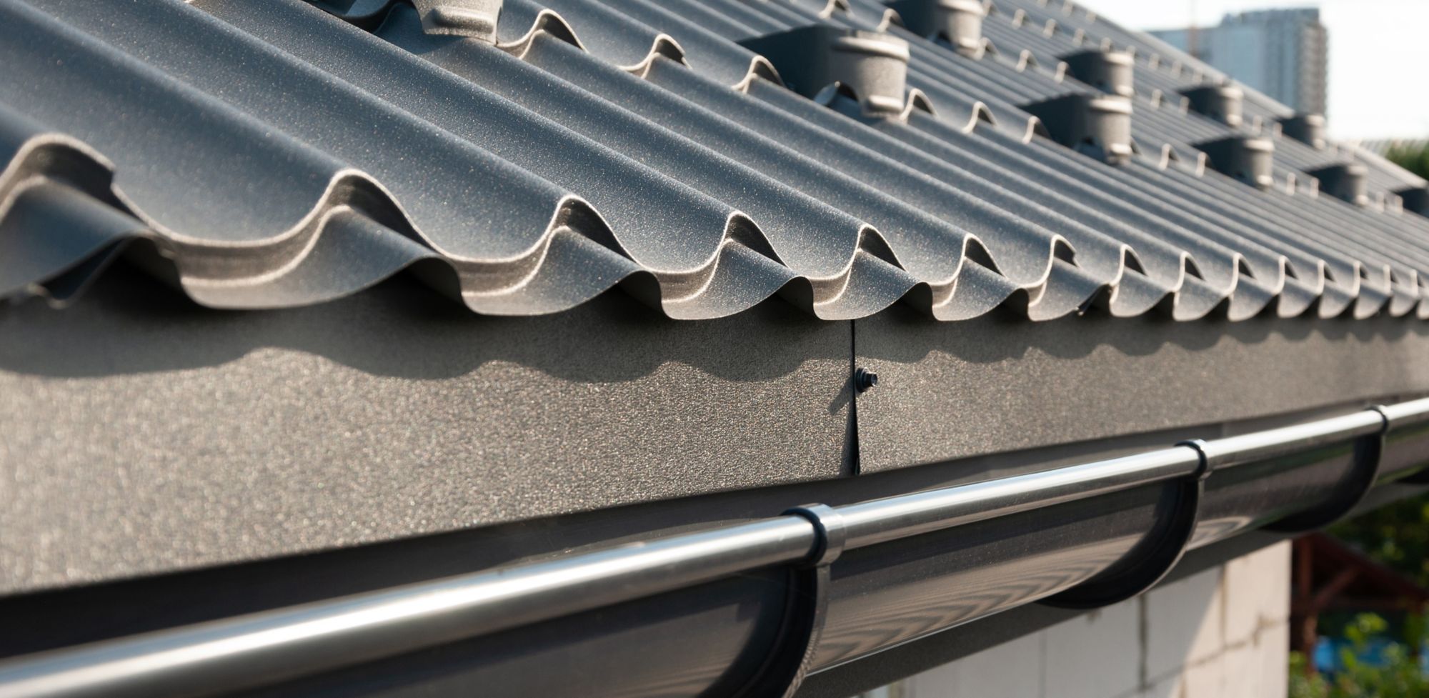 Bluish gray, metal roofing is shown from the gutter angle. 