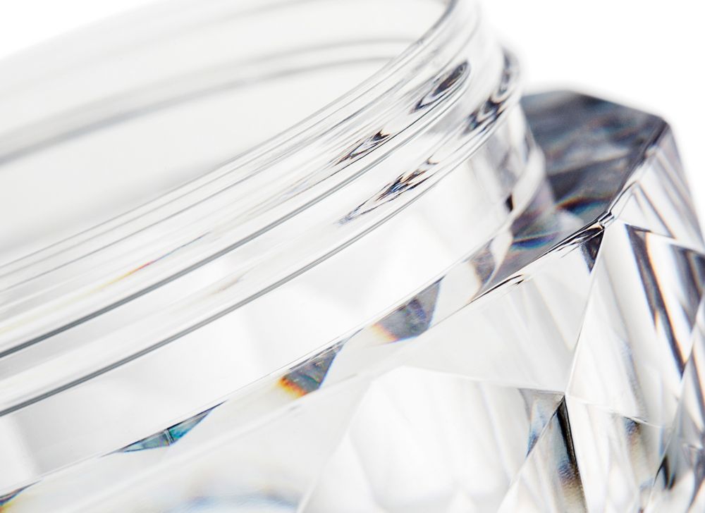 Close-up of an open, thick cosmetic jar 