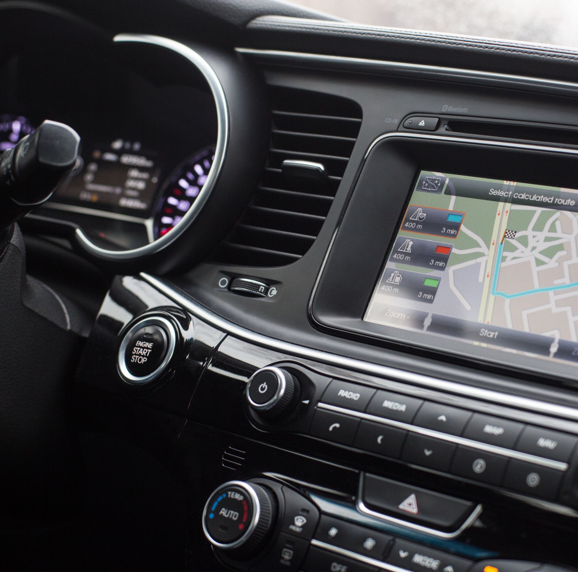 A car dashboard is illuminated, including the odometer and GPS screen. 