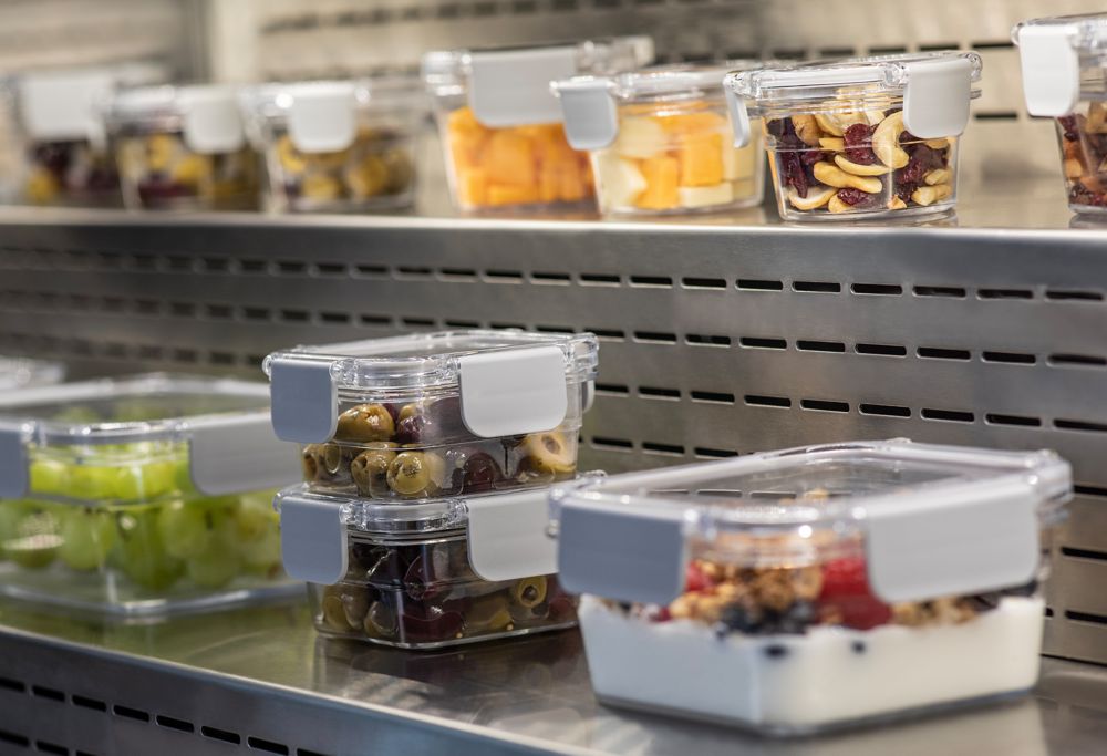 Two rows of reusable storage containers filled with a variety of food. 