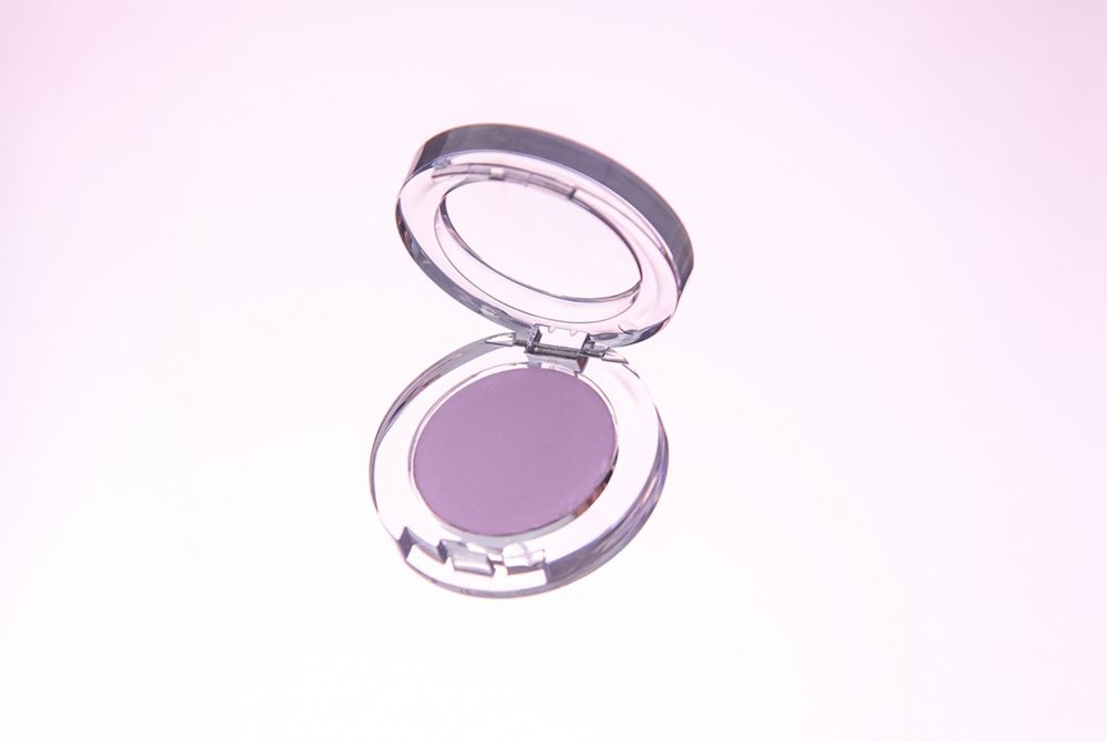 Purple eyeshadow powder in a crystal-clear Gemini makeup compact.   