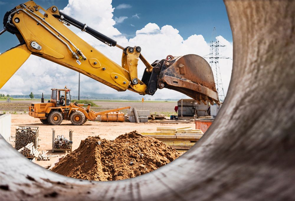 An excavator grabs dirt at a construction site.  
