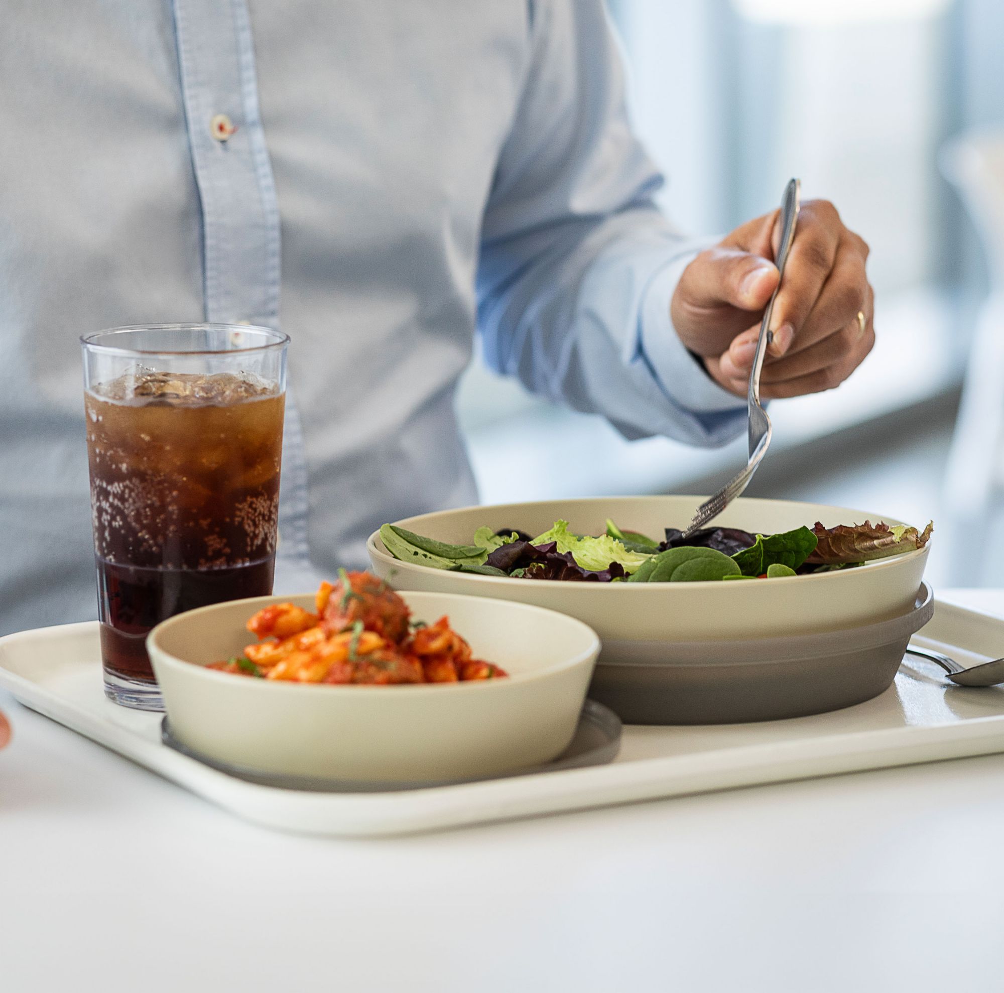 A person eats from reusable serveware made with Tritan from Eastman. 