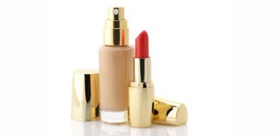 Foundation bottle and red lipstick with gold accents 