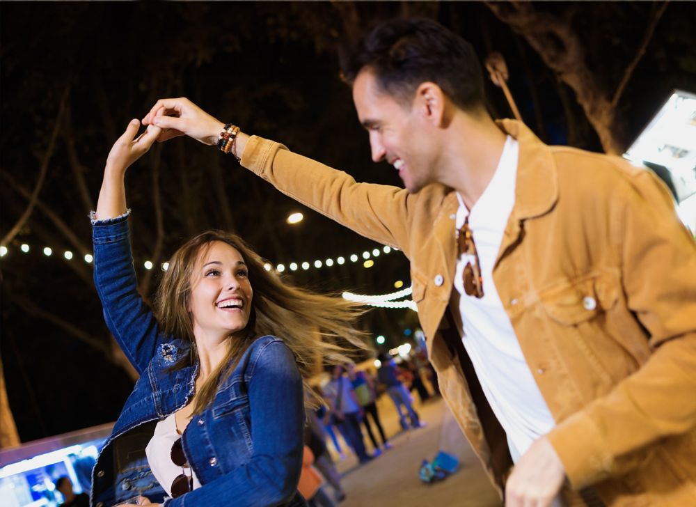 A couple dances together at an outdoor event. 