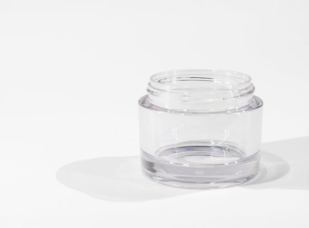 A clear, open cosmetic jar.   