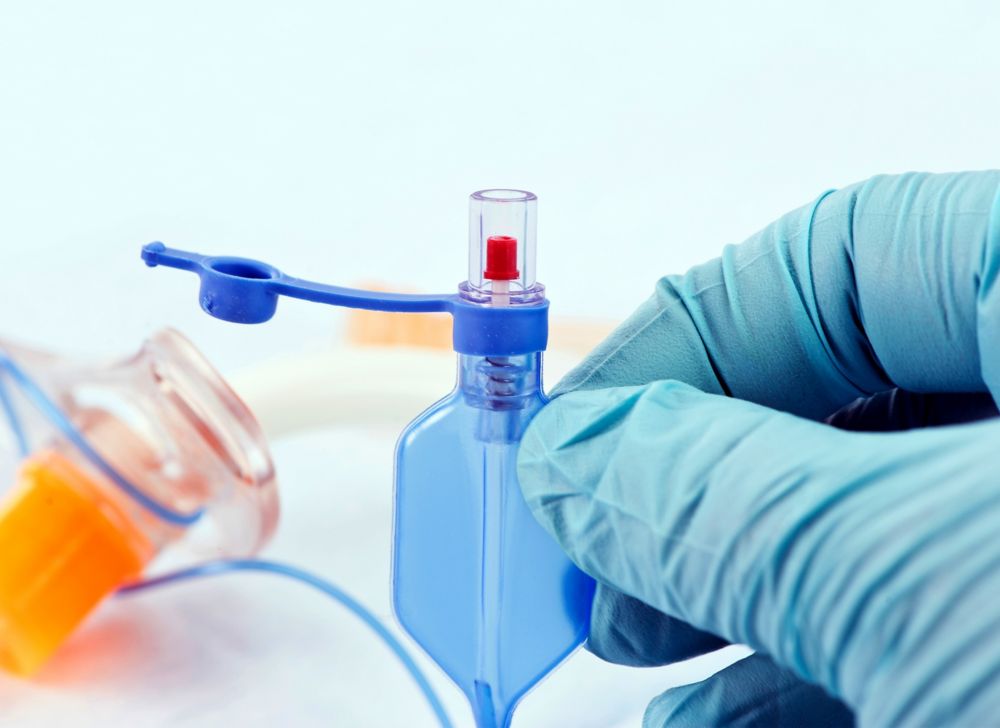 Gloved hand holding a cuffed trachea tube.  