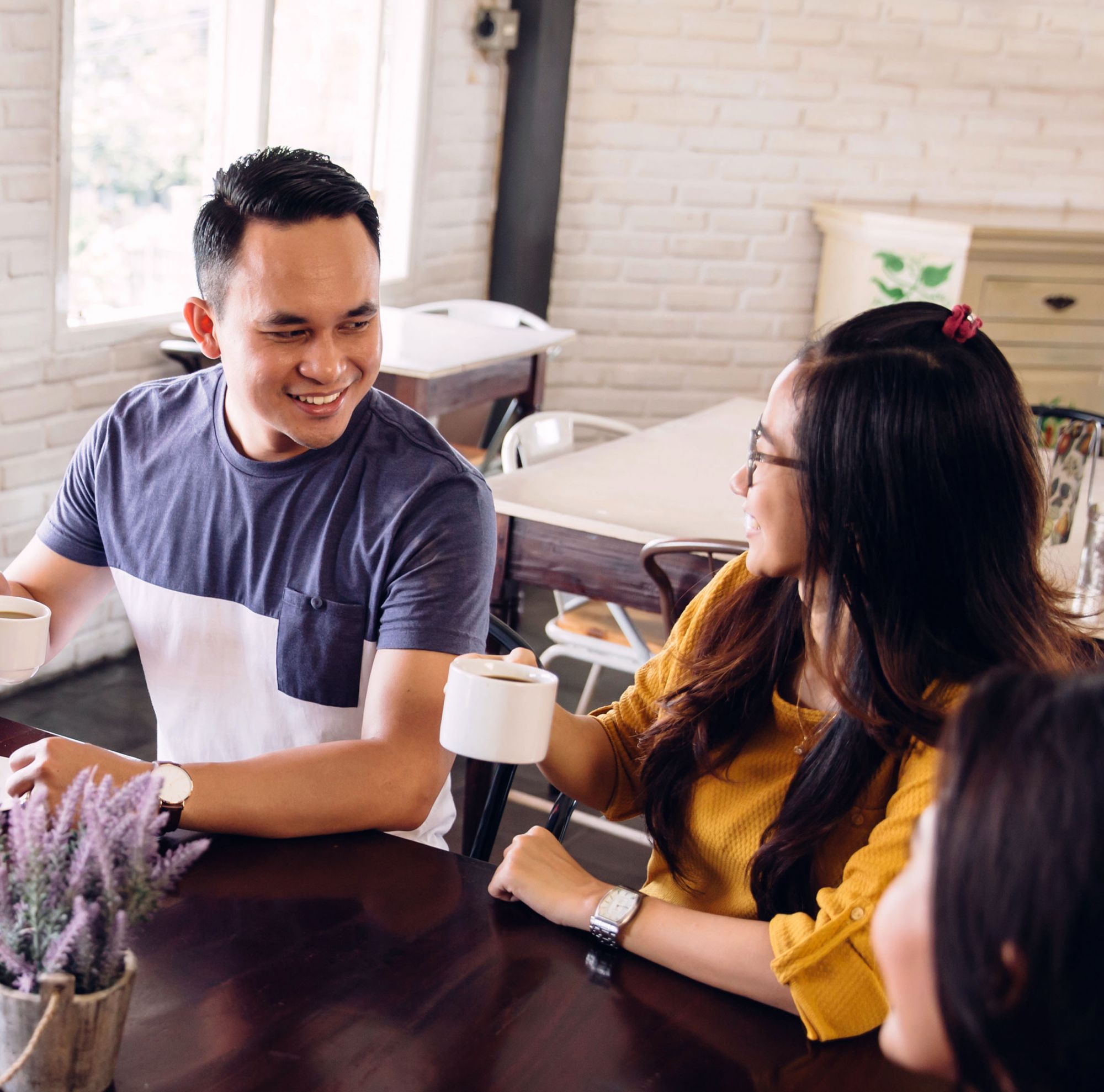 A group of people smiling and having coffee. 