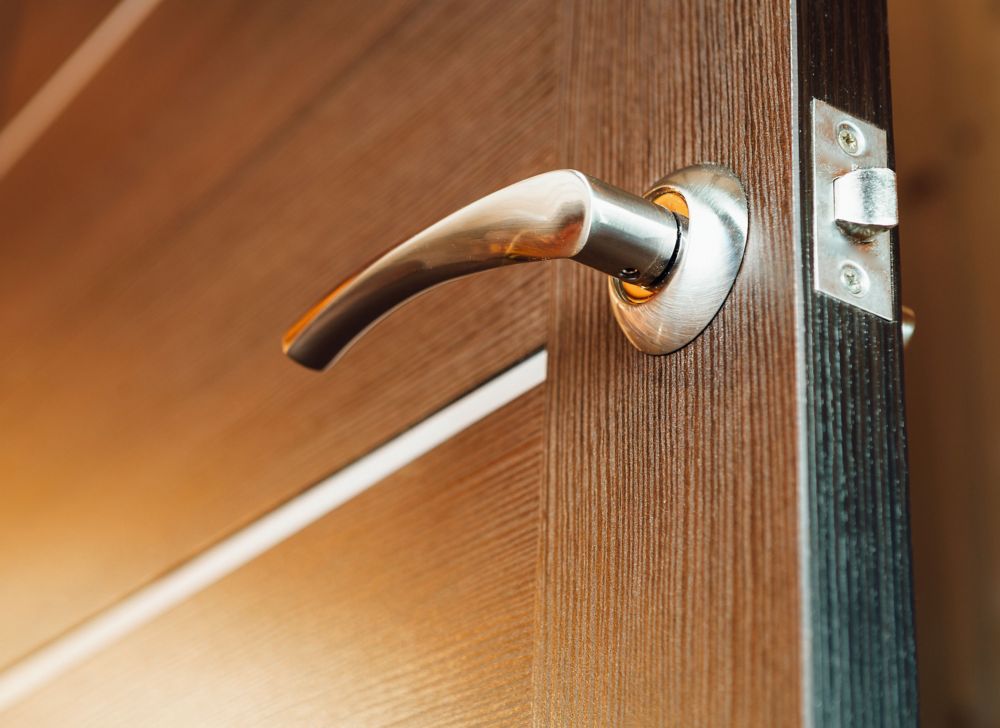 A close-up of a wood door and its metal door handle. 