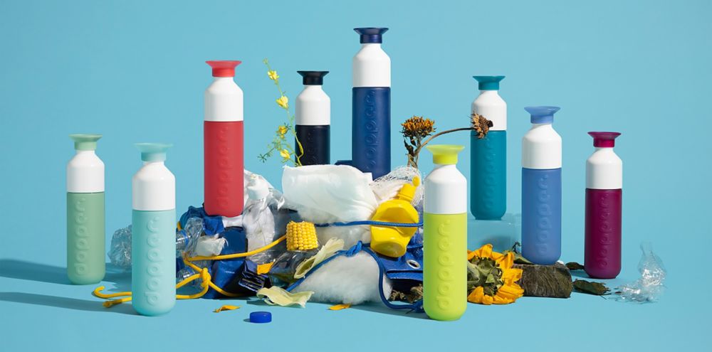 Full color collection of reusable Dopper bottles surrounding plastic waste 