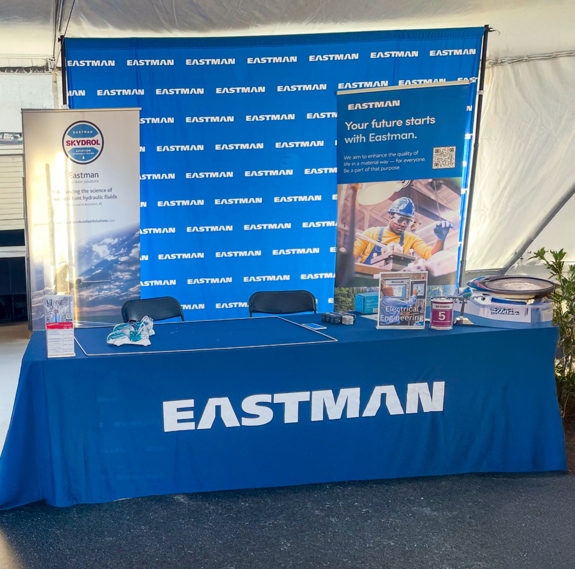 A table at a career fair has Eastman branded items. 