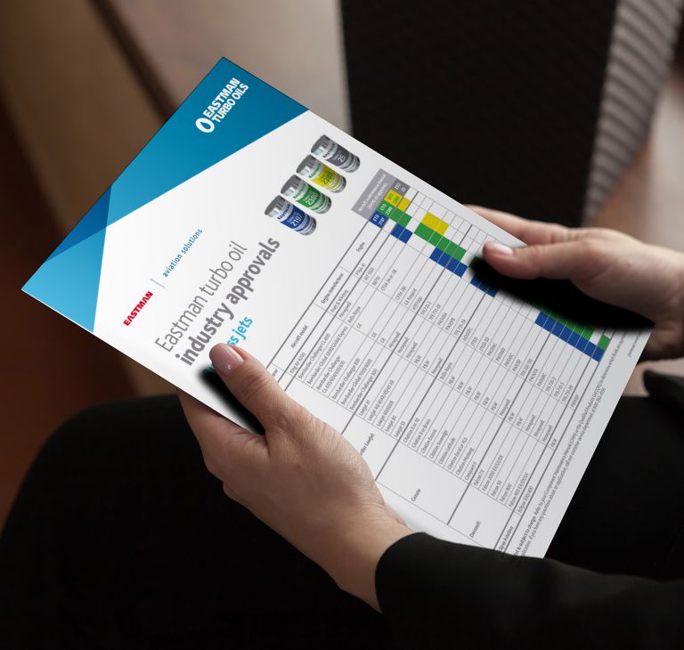 A person holds a paper listing Eastman turbo oil industry approvals. 