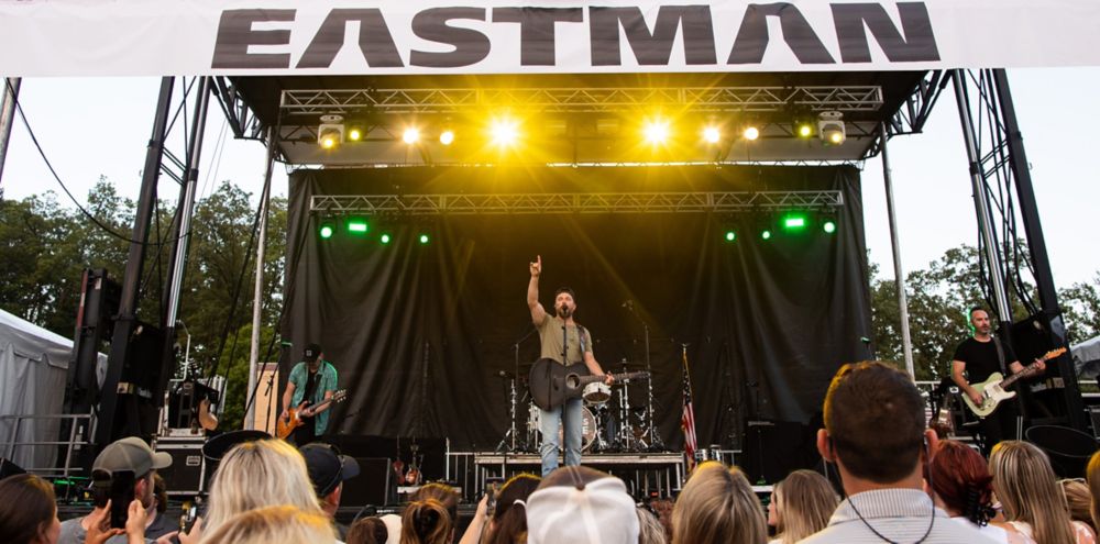 Chris Lane and his band performing on stage under an Eastman banner at Fun Fest in Kingsport,  Tennessee 