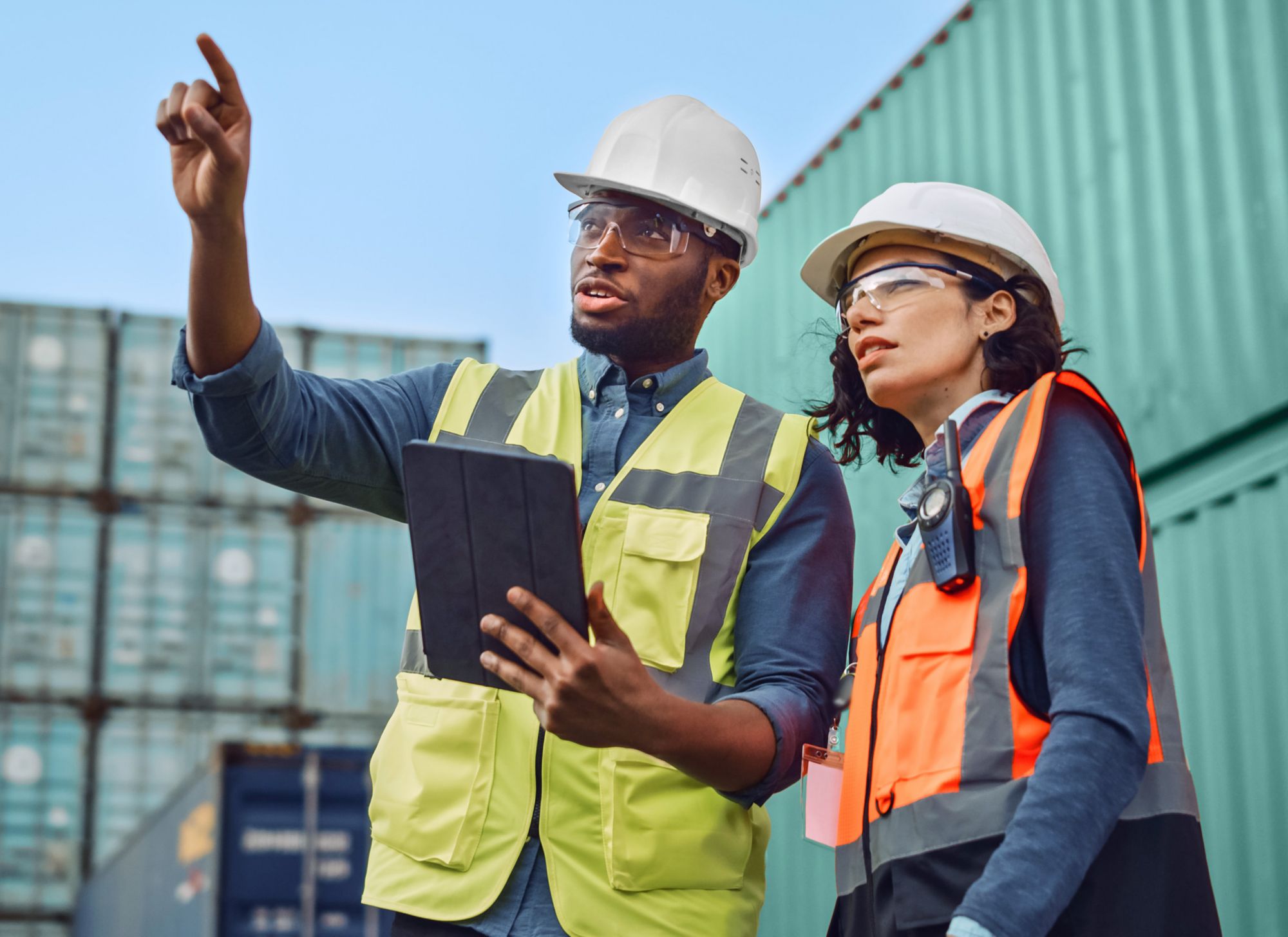 Dos ingenieros con chalecos, cascos y gafas de seguridad 