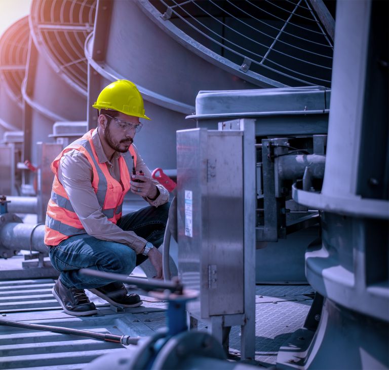 An expert technician inspects a vent in an industrial facility.  