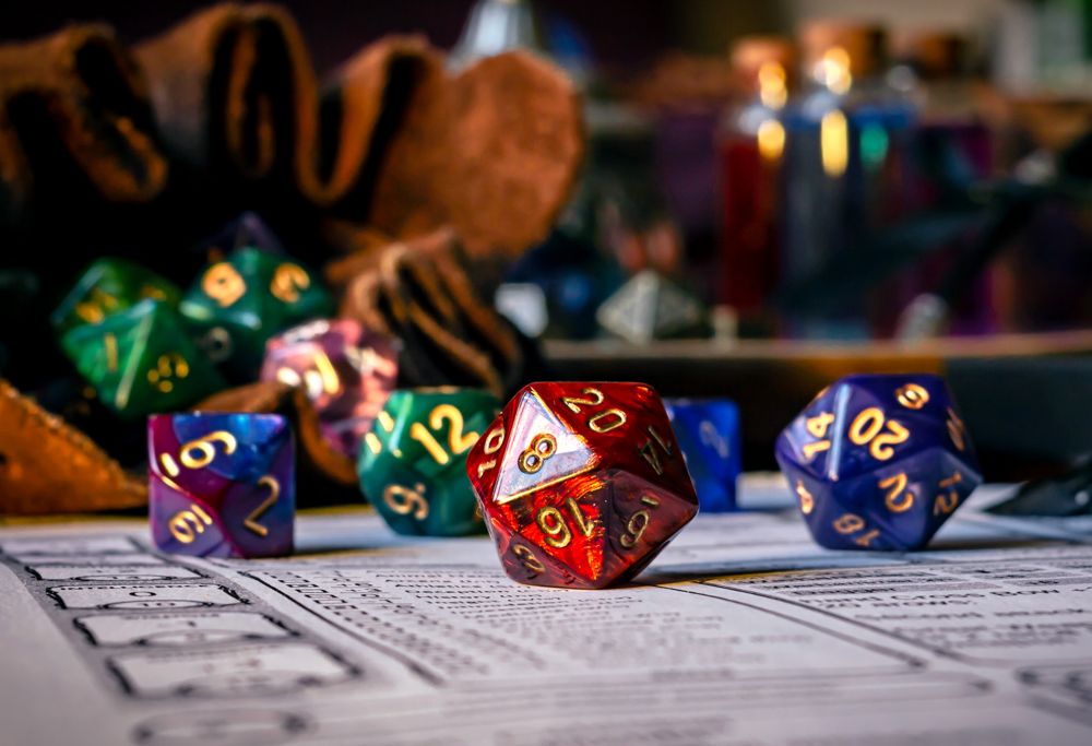 A colorful dice set sits on top of a game character sheet.  