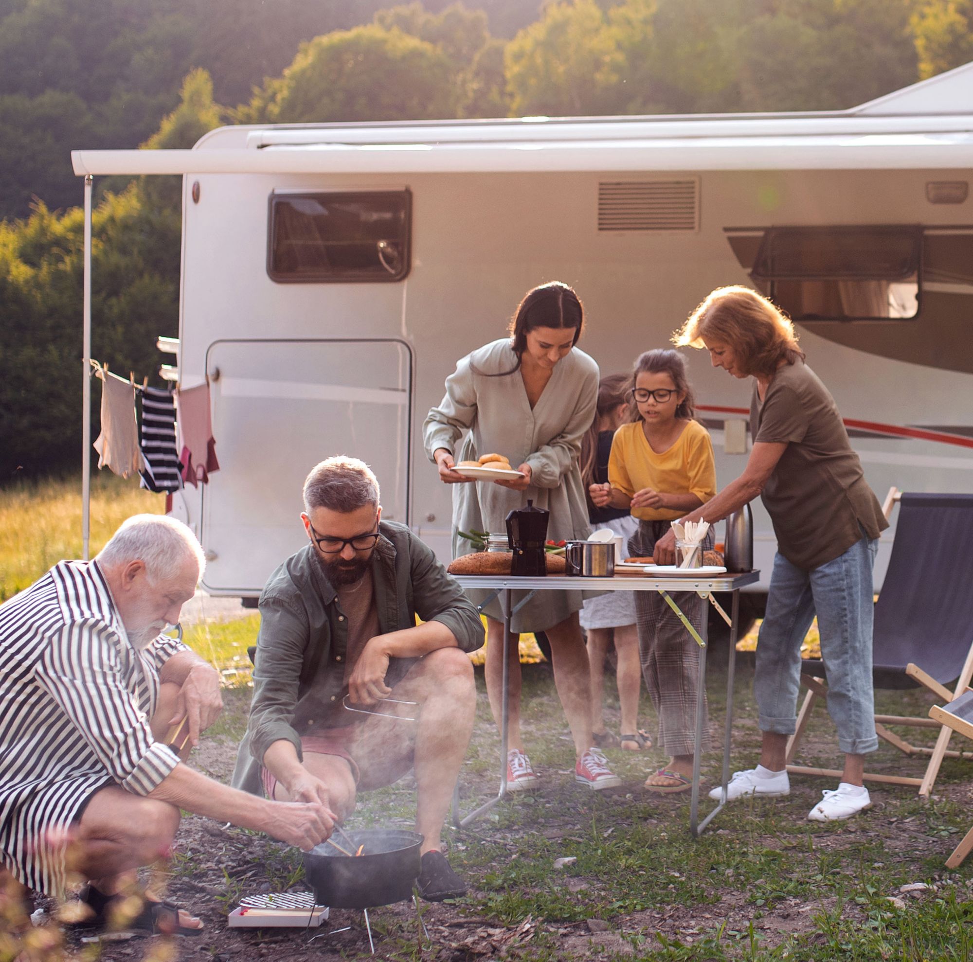 A family prepares diner at their RV campsite. 