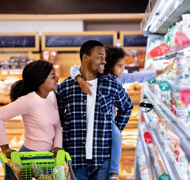 A family of three grocery shopping. 