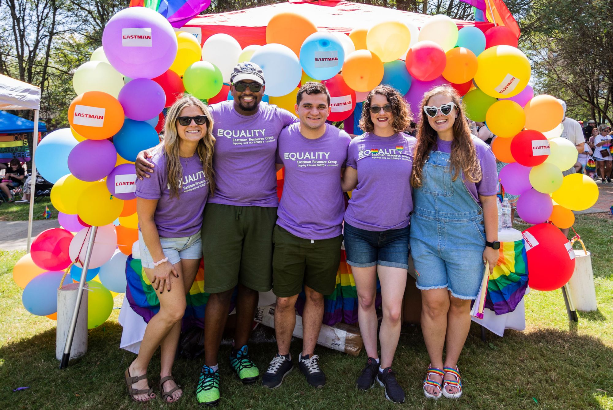Members of Equality resource group stand in front of Eastman’s booth at TriPride 