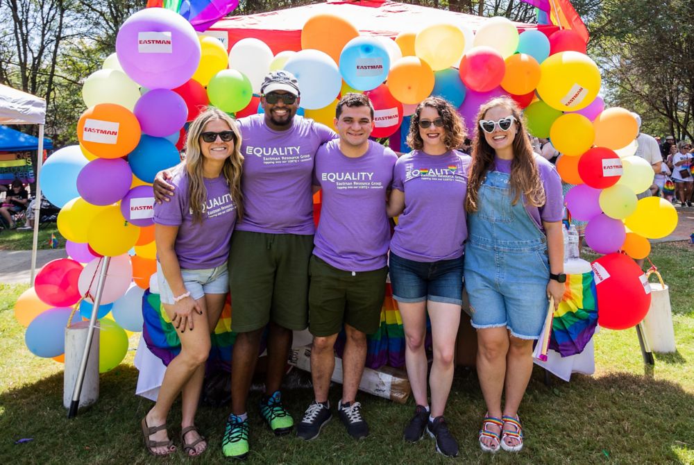 Members of Equality resource group stand in front of Eastman’s booth at TriPride 