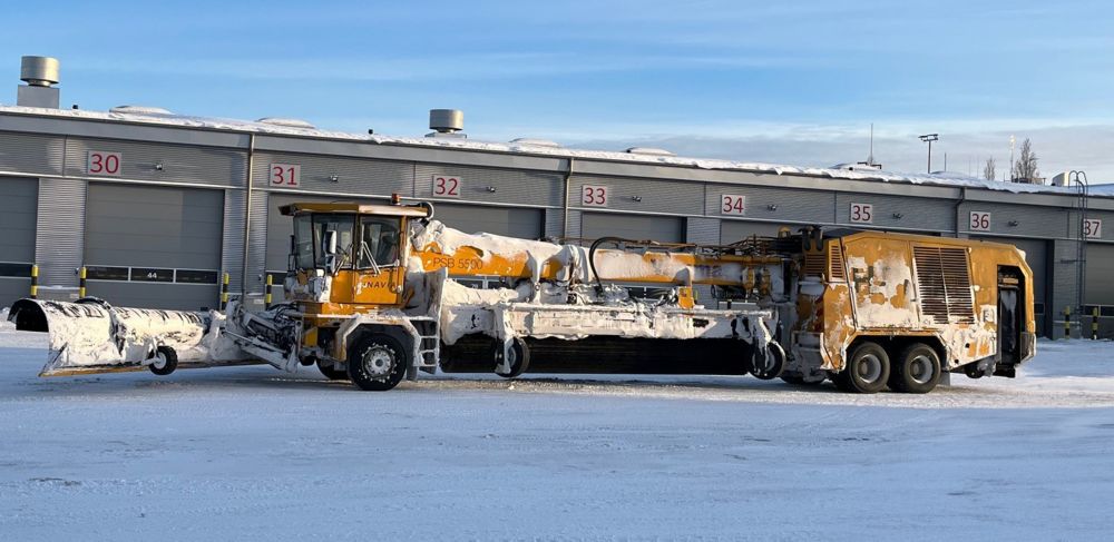 A snow plow at the Helsinki airport is covered in snow and ice 